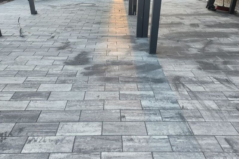 Gepflasterte Einfahrt unter einem Carport im Abendlicht